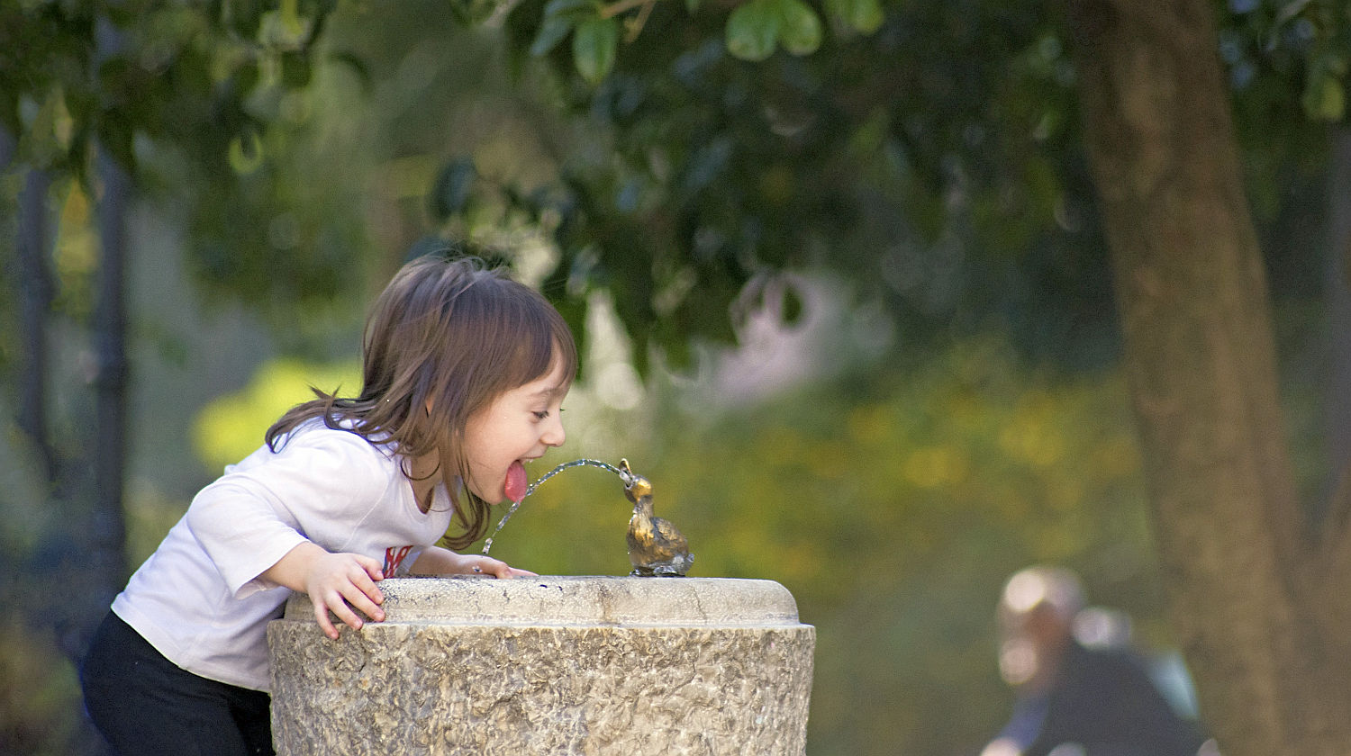 Feature | Girl thirsty drink fountain water | Is it Safe to Drink from a Public Water Fountain?